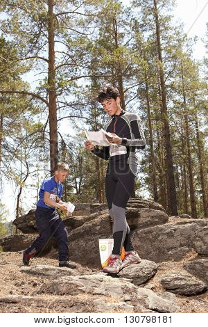 RUSSIA, ULAN-UDE - MAY 22, 2016: Russian Azimut - 2016. Orienteering competition is held annually in the Buryatia region. People at at control point at orienteering course.