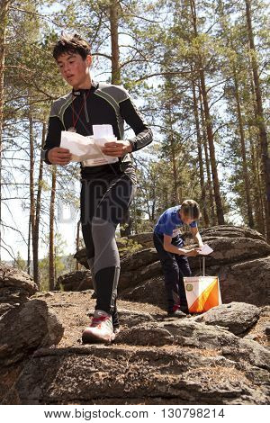 RUSSIA, ULAN-UDE - MAY 22, 2016: Russian Azimut - 2016. Orienteering competition is held annually in the Buryatia region. People at at control point at orienteering course.