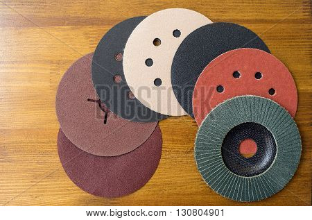 Abrasive disks for metal and stonewood grinding cutting. Set of abrasive materials on wooden background vertical view.