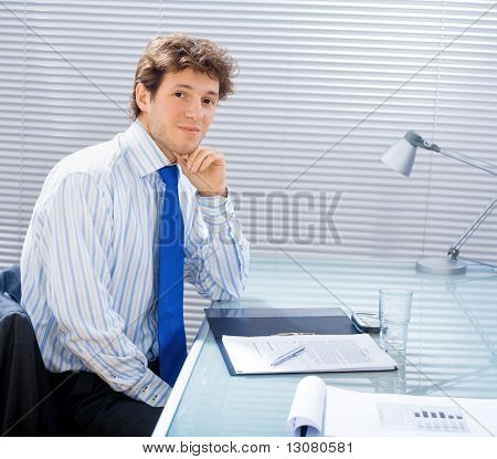 Jung gut aussehend kaufmann sitzen am Schreibtisch im Büro und arbeiten.