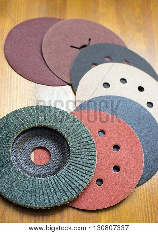 Abrasive disks for metal and stonewood grinding cutting. Set of abrasive materials on wooden background vertical view.