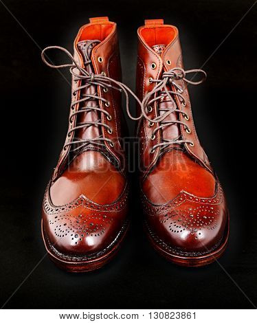 Wingtip dark chili brown dress boots full size isolated on black background