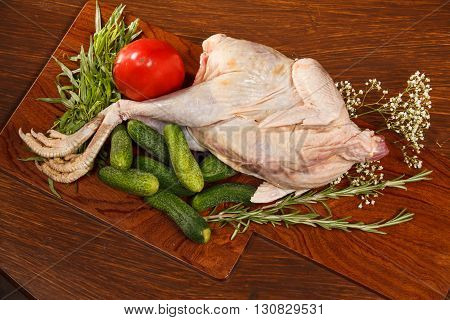 Raw chicken with vegetables on a wooden table