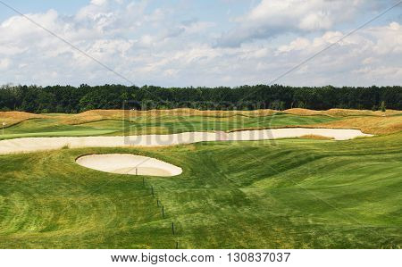 Perfect golf course. Golf club. Green summer golf course landscape with sand bankers. Golf field beautiful landscape with sand traps.