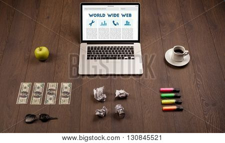 Laptop computer on wooden desk with office suplies