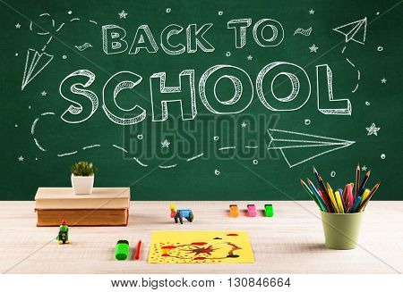 Back to school concepty with writing on blackboard and desk, apple, books, items