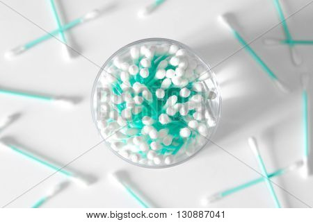 Turquoise cotton swabs in clear glass jar isolated on white