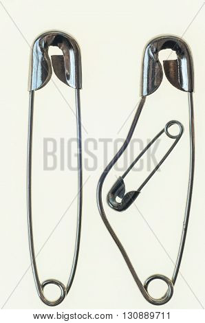 family of safety pins with pregnant mother and father to her  side