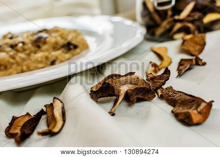 Dry mushrooms and traditional italian risotto on white plate