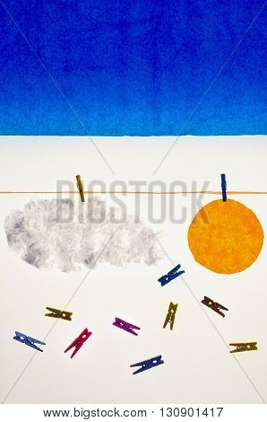 composition with clothes pegs and a fake sun and sky