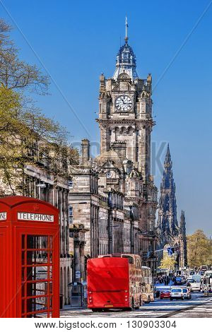 Edinburgh With Phone Booths And Red Bus Against Clocktower In Scotland, Uk