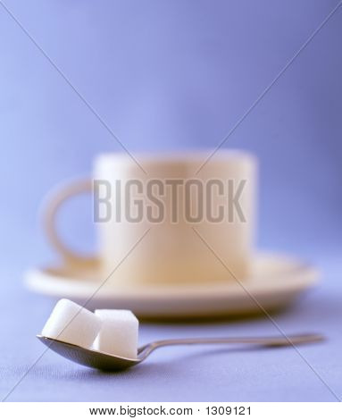 Zwei Würfelzucker mit einer Tasse Kaffee auf einer Untertasse