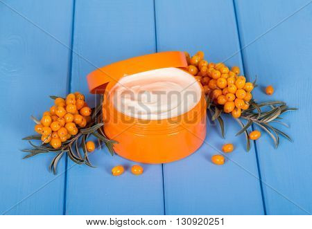 Seabuckthorn and the bank with the cream-colored background on the wood blue.