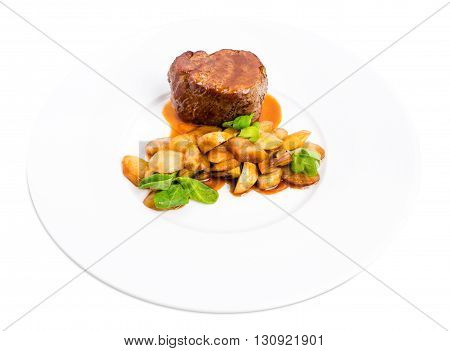 Delicious beef steak in demiglas sauce with vegetable garnish. Isolated on a white background.