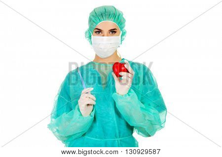 Young female cardiologist surgeron holding heart and scalpel