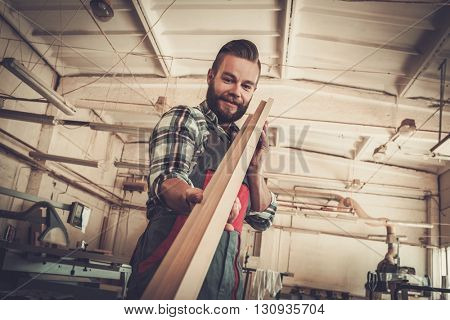 Carpenter doing his job in carpentry workshop.