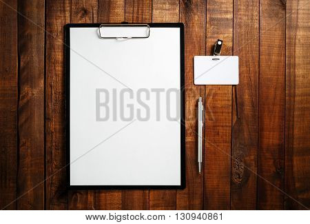 Corporate identity template on vintage wooden table background. Blank ID template. Blank letterhead badge and pen. Branding template. Mock-up for design portfolios. Top view.