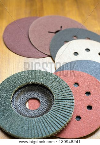 Abrasive disks for metal and stonewood grinding cutting. Set of abrasive materials on wooden background vertical view.