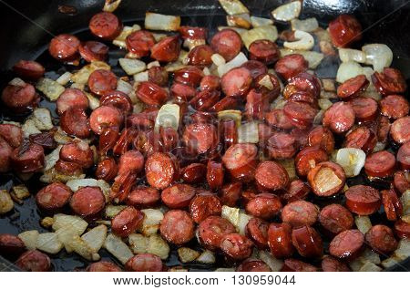 Grilled sausages with onions in a grill pan