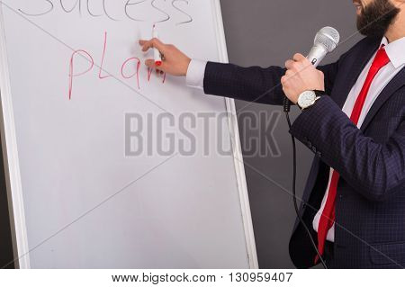 Business coach holds training. Cute business man in a nice suit.