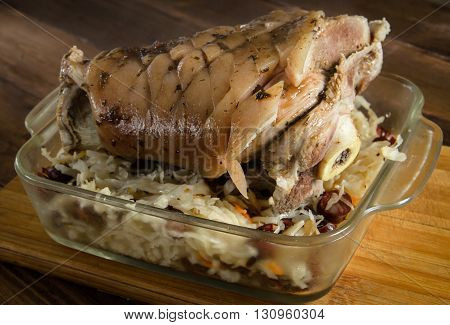Boiled pork shank on a wooden table with sauerkraut