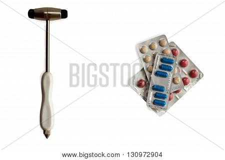 neurological hammer and stack of colorful pills in blisters isolared on white. background with copy space