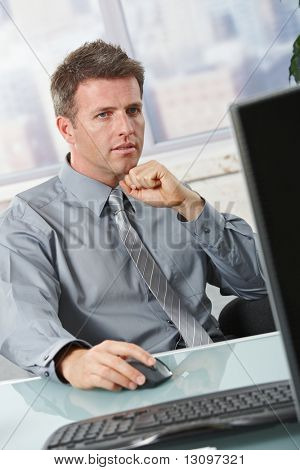 Empresario determinado concentrarse en la tarea de equipo sentado en la oficina.