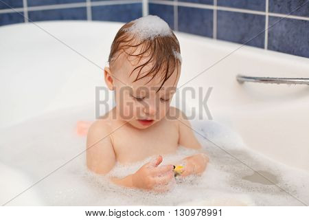 Baby in the bathroom with foam bath