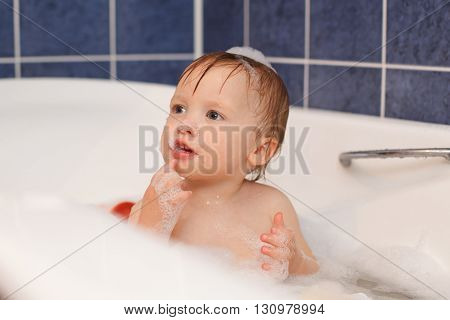 Baby in the bathroom with foam bath