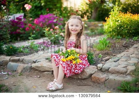 Cute happy girl in a blooming garden