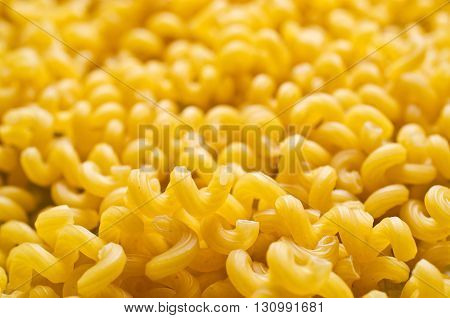 Background of dry pasta cavatappi. Selective focus.