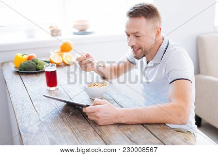 Body Requirements. Attractive Gay Positive Man Holding Spoon While Trying Granola And Studying Blog 