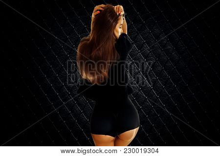 Slender Beautiful Lady In Black Bodie Turned Her Back To The Camera Isolated On White Background