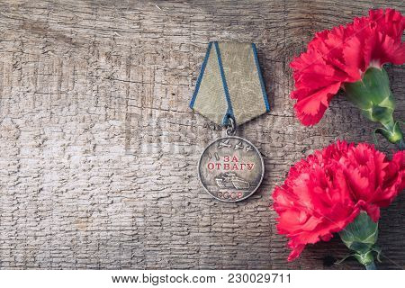 The Old Soviet Medal For Bravery Of The Second World War With A Red Carnation, Victory Day May 9 Pos