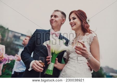 Stylish And Gorgeous Wedding Couple With Glasses Of Champagne.