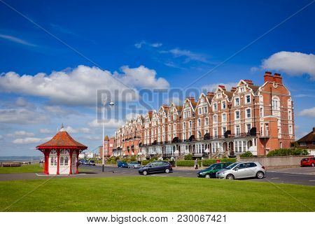 BEXHILL-ON-SEA, UK - JUN 4, 2013: Victorian wooden seafront shelter and buildings at popular seaside resort Bexhill-on-Sea in East Sussex