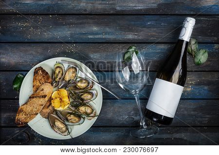 Mussels And Bread Toasts On On A White Plate. Served With Half Grilled Lemon, Fork And Leaves Of Kaf