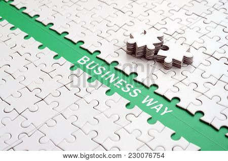 Business Way. The Green Path Is Laid On The Platform Of A White Folded Jigsaw Puzzle. The Missing El
