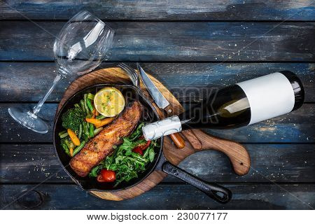 Grilled Salmon Fillet In A Frying Pan, Vegetables, Arugula With A Lemon Served With Cutlery And Glas
