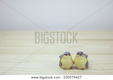 A Little Two Ceramic Birds On Wooden Table. Focus On Bird