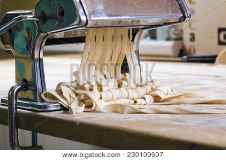 Process Of Production Of  Pasta. Fresh Pasta And Pasta Machine On Kitchen Table