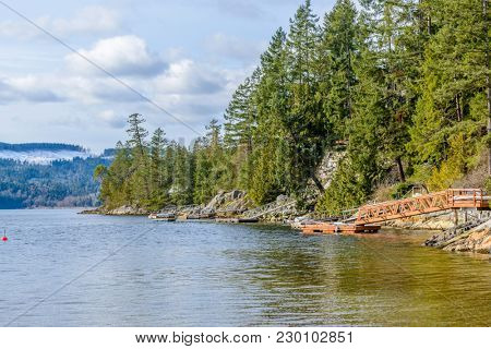 Fantastic view over ocean, snow mountain and rocks at Sechelt inlet in Vancouver, Canada.