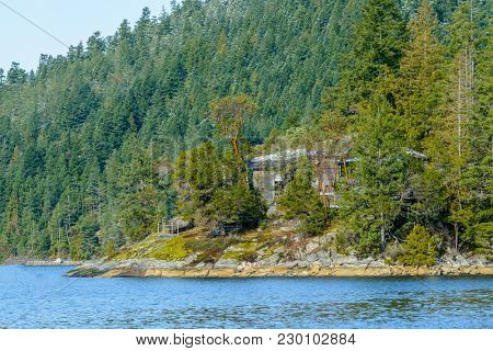 Fantastic view over ocean, snow mountain and rocks at Sechelt inlet in Vancouver, Canada.