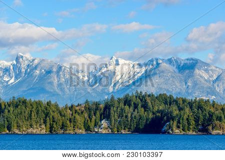 Fantastic view over ocean, snow mountain and rocks at Sechelt inlet in Vancouver, Canada.