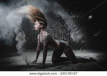 Girl Dansing With Flour During Photoshoot On Black Background