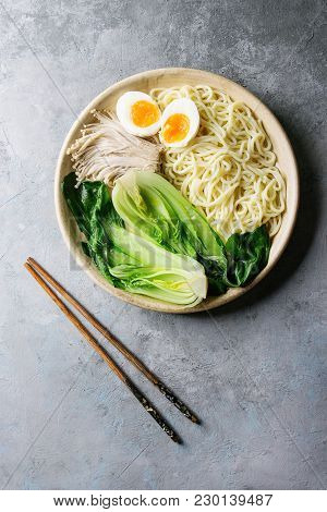Asian Dish Udon Noodles With Boiled Egg, Mushrooms, Boc Choy Served In Ceramic Bowl With Chopsticks 