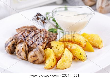 Pork Steak With Grilled Champignons And Potato Slices.
