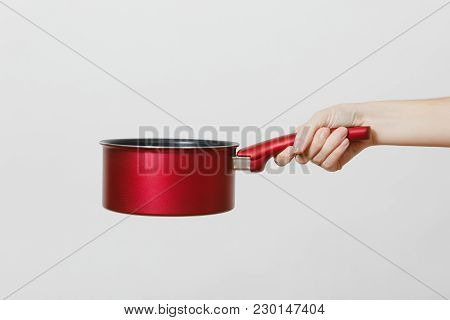 Close Up Of Female Hand Horizontal Holding Red Round Stewpot Isolated On White Background. Kitchen U