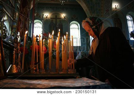 Voyutyn, Ukraine - 14 October 2008: Ukrainian Parishioners Of The Orthodox Church Light Up Candles D