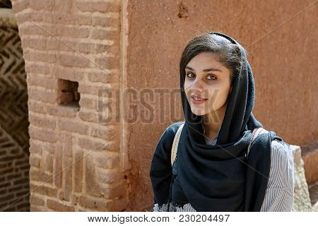Abyaneh, Iran - April 26, 2017: Young Iranian Woman In A Hijab Walks Around A Traditional Village In